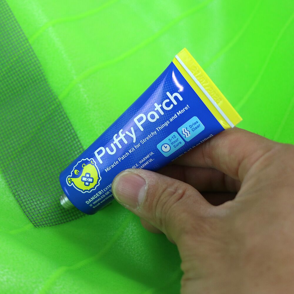 Hand holding Puffy Patch adhesive tube